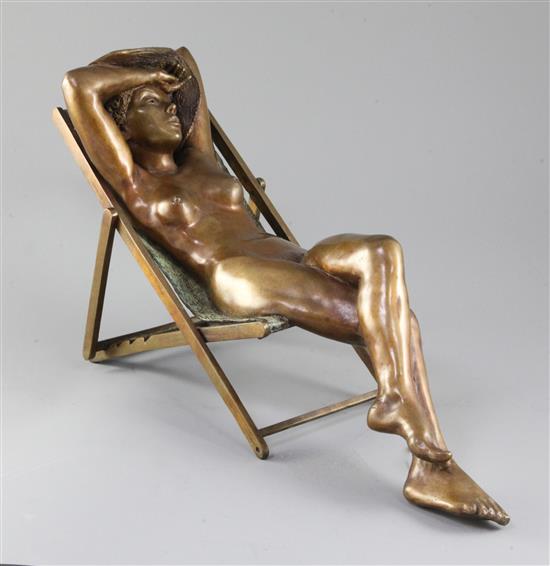 Desmond Fountain (Bermudan, b.1946). A bronze figure of a nude young woman reclining in a deck chair, length 17in.